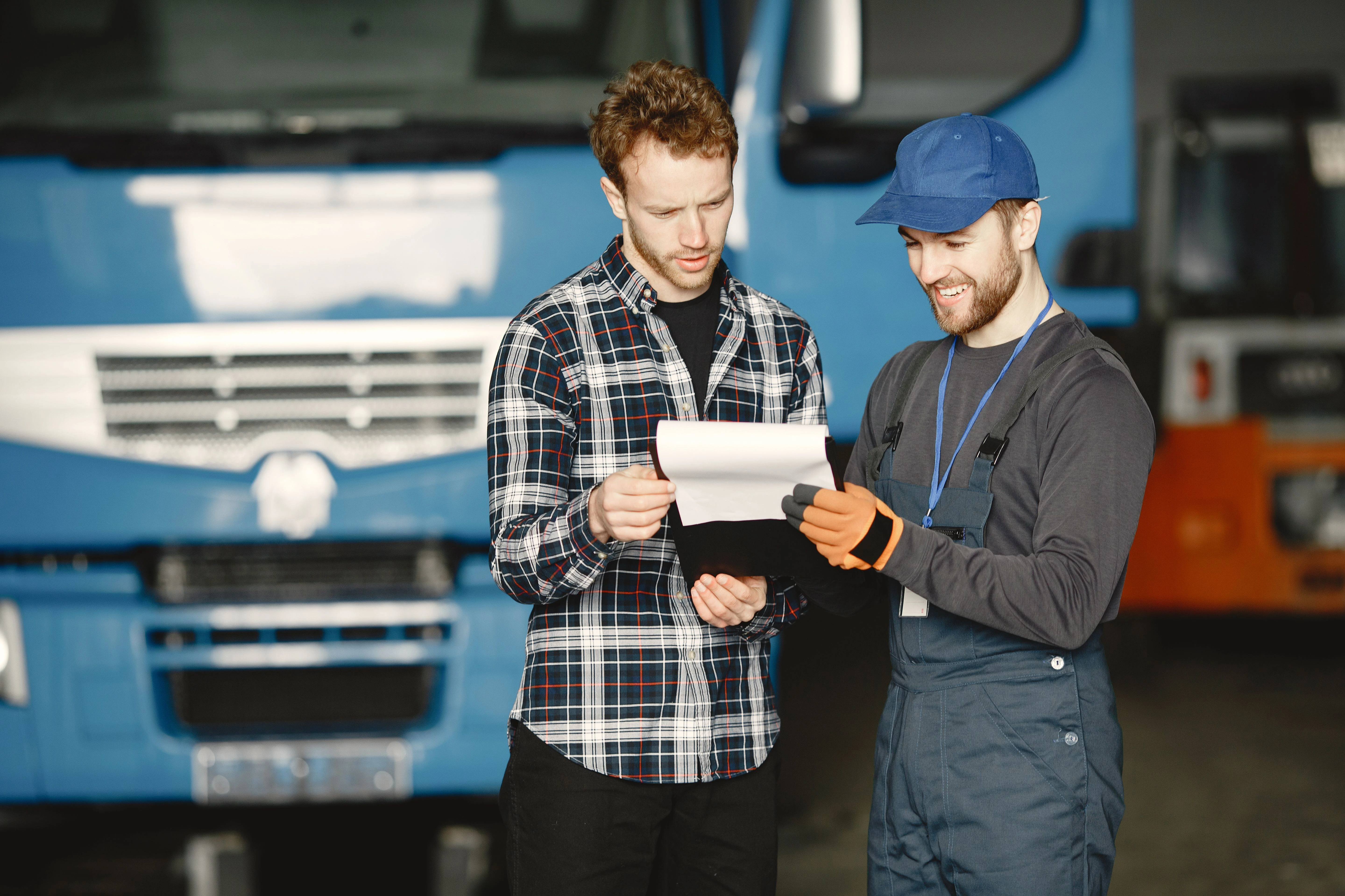 seguro de carga en honduras foto de dos personas revisando una lista de carga frente a un camion